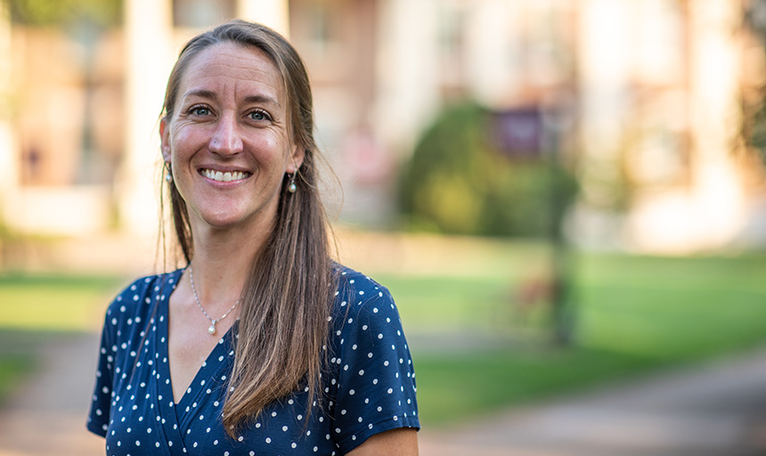 Liz Ackley smiles for a portrait photo on the campus quad