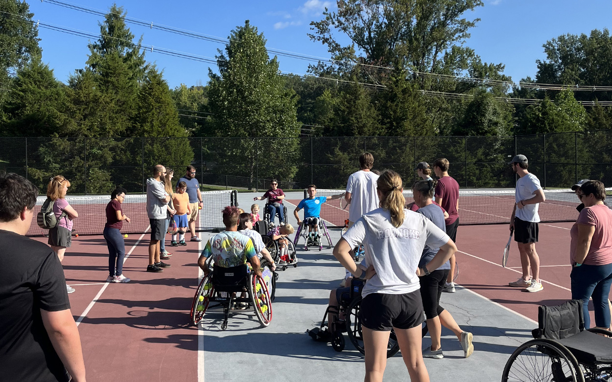 Children and volunteers playing wheelchair tennis on the Roanoke College tennis courts