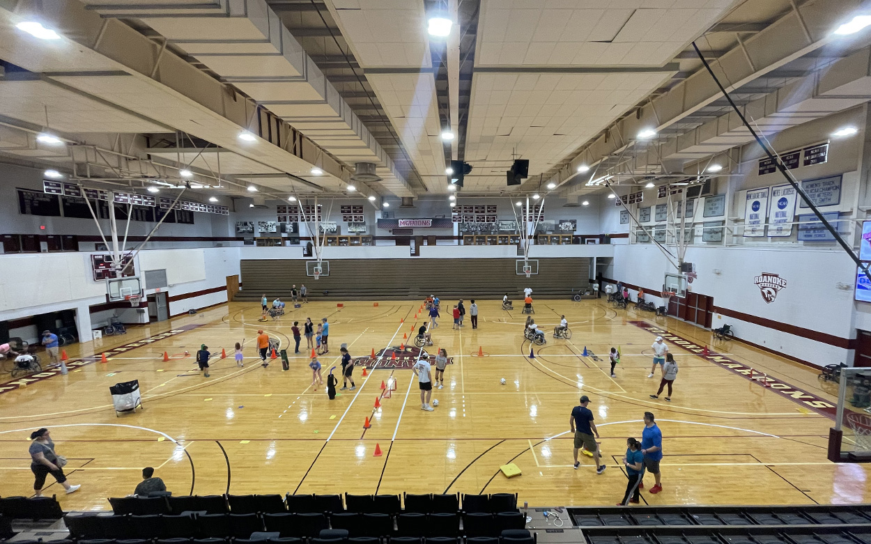 Overhead photo of a Roanoke College gym set up for MAPLE'S Kids including an obstacle course marked by orange cones