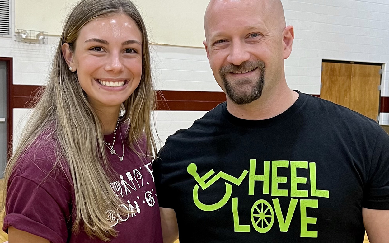 Julia Bassett and a volunteer from the nonprofit Wheel Love smiling for a photo