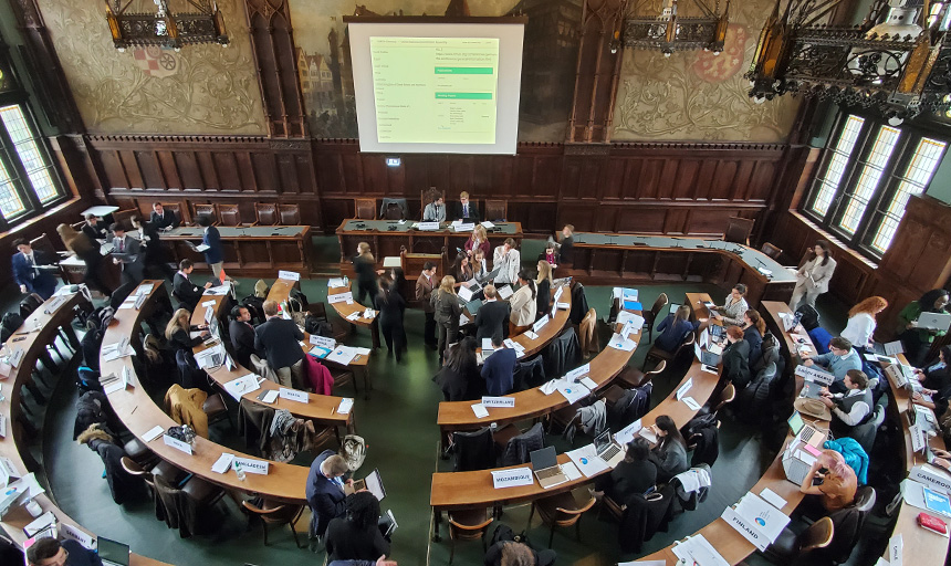 Overhead shot of students huddled together working in a well-appointed hall of government in Germany