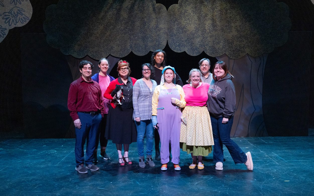 The cast, crew and faculty of "Sleeping Handsome" smile on stage for a group photo