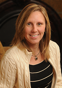 Headshot of a blonde woman in black shirt and ivory sweater