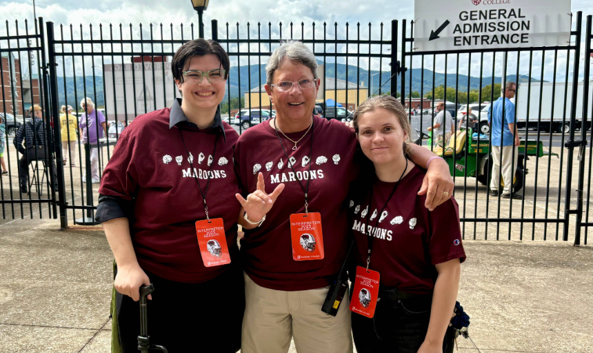 Three people smile for a photo