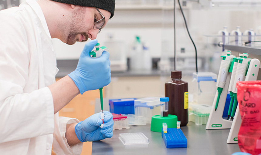 A student working with a sample and a pipette in a lab