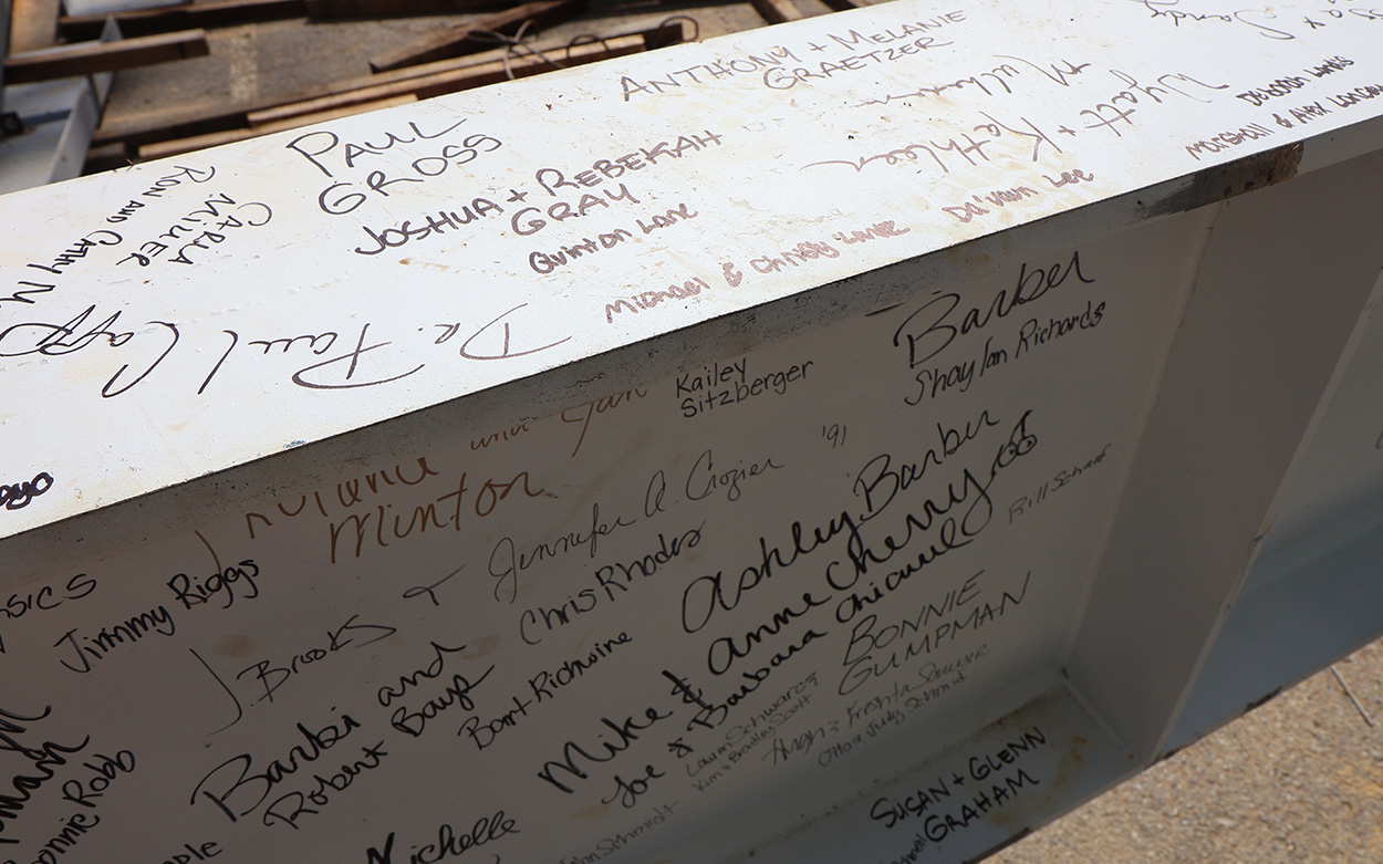 Close-up of names handwritten onto a steel beam