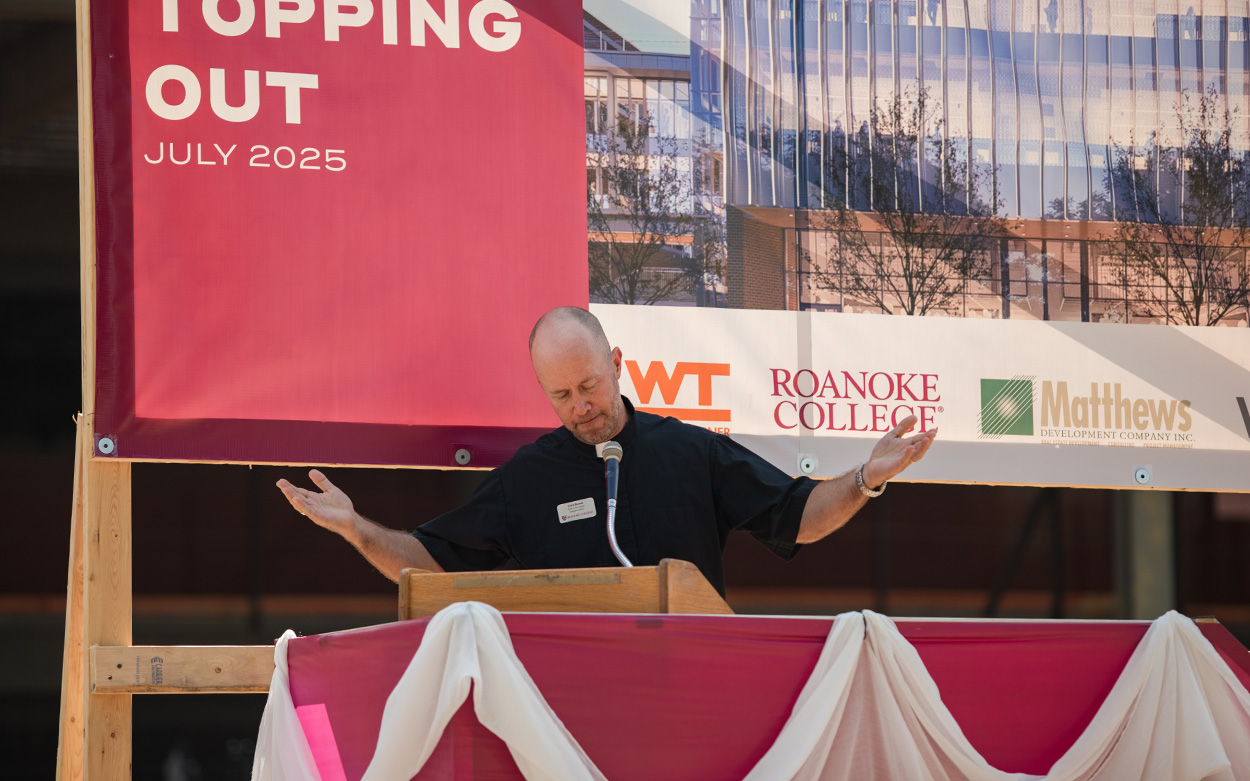 A man leads a prayer from a podium