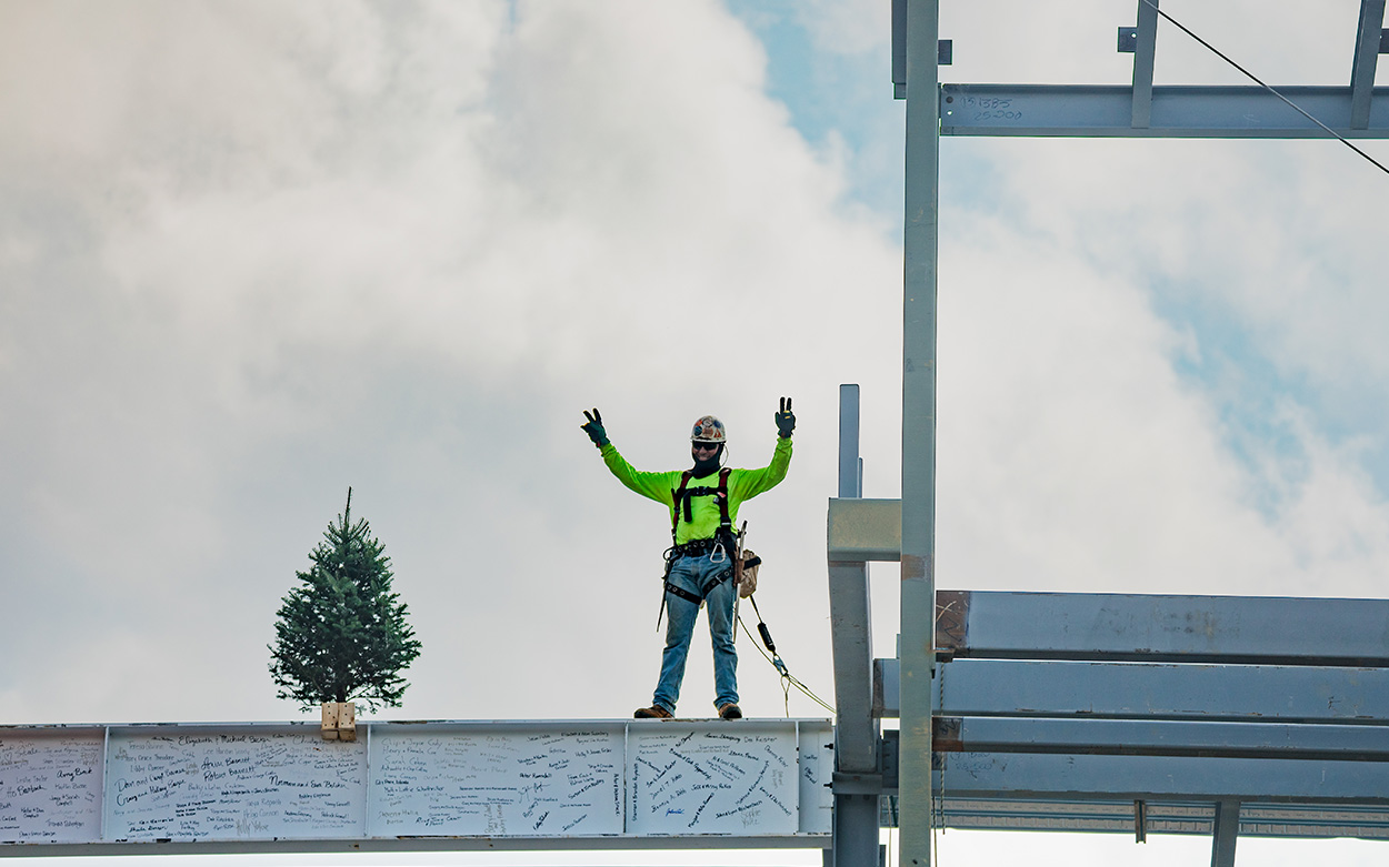 A construction worker gives a peace sign
