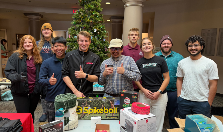 Students and staff smile for a photo during a campus food drive