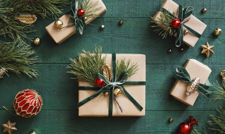 Wrapped gifts adorned with ribbons, colorful bells and sprigs of evergreen