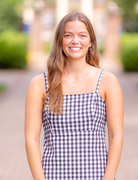 Photo of young woman in white-and-purple checkered dress
