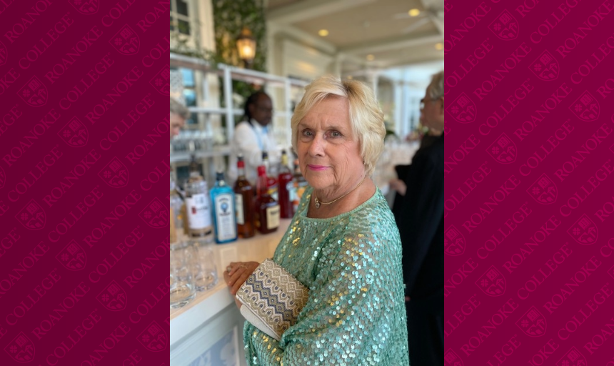 Woman wearing a teal sequin top framed by a Maroon background