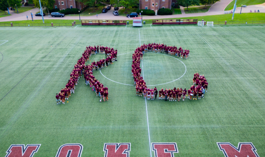 Students group together to form the letters R and C for a photo