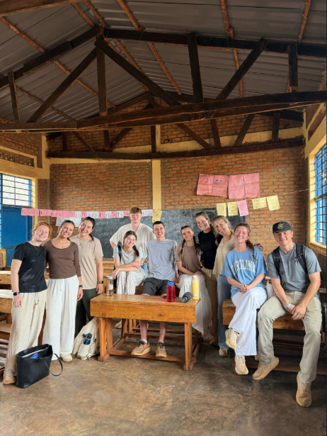 A group of students pose for a photo together in a classroom in Rwanda. 