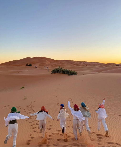 Students run through the desert in Morocco. 