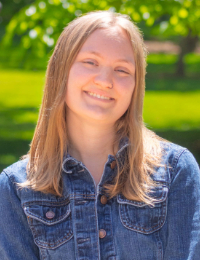 Head shot of young woman with long blonde hair in a denim jacket