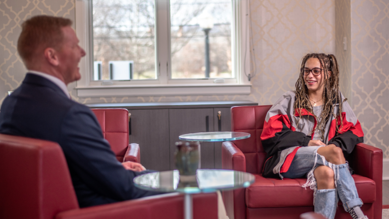 A student smiles while talking with a mentor in the career center