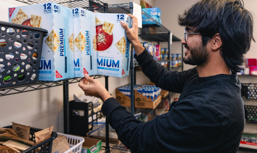 A student stocking items on a shelf