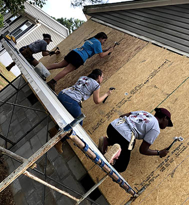 Students hammering on wood