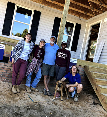 Students posing for a photo in front of the house