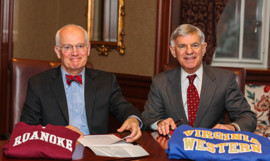 Roanoke College President Michael Maxey and Virginia Western President Dr. Robert H. Sandel sign the agreement.