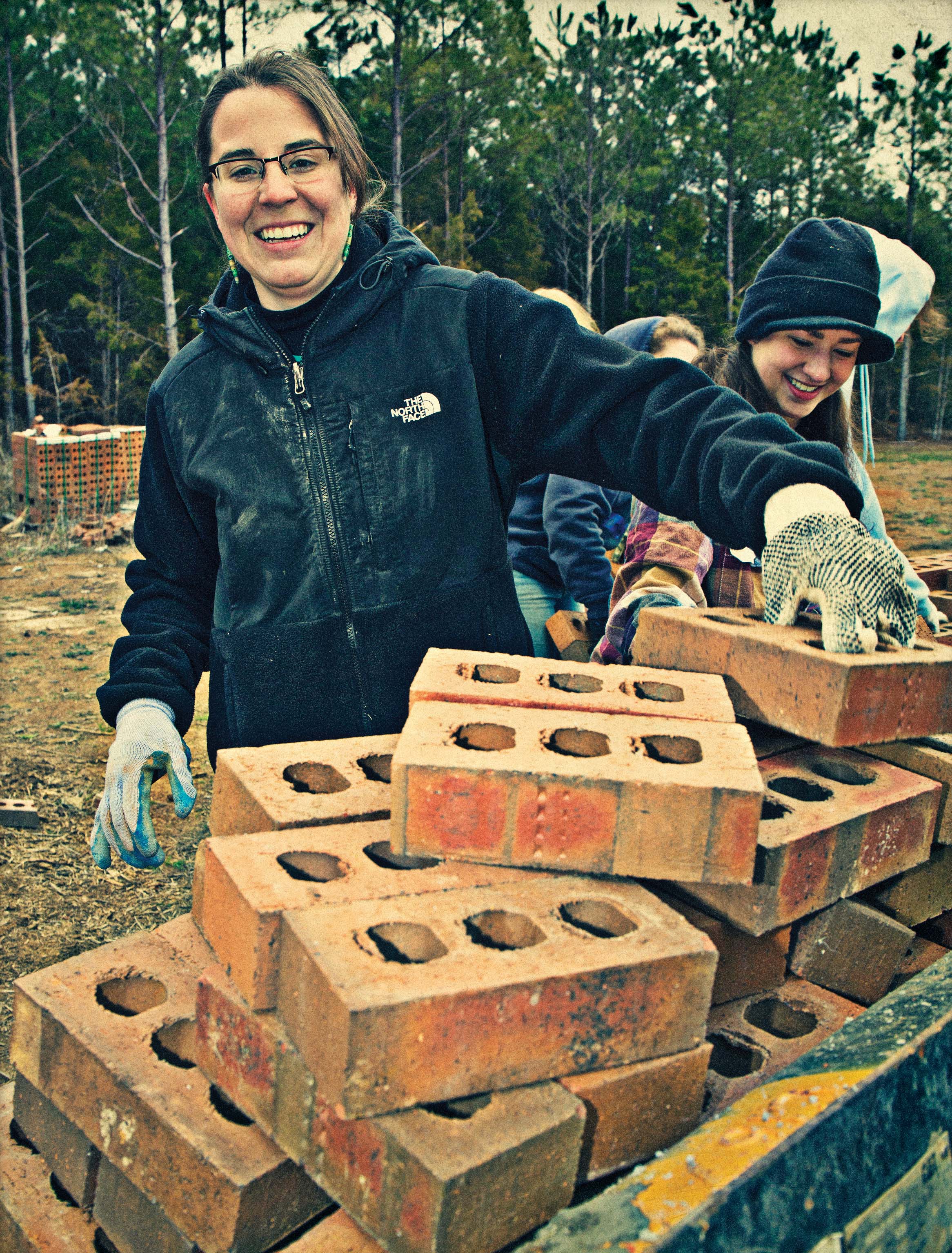 Talisha Beha standing by a pile of bricks