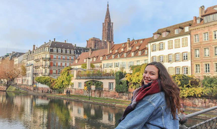 Alexandra Gautier smiles for a photo while looking out over a scenic canal in France