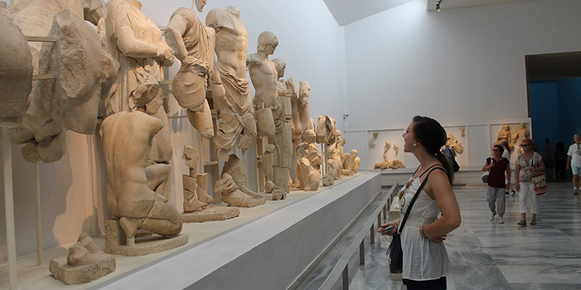 Student looking at sculptures in Greece