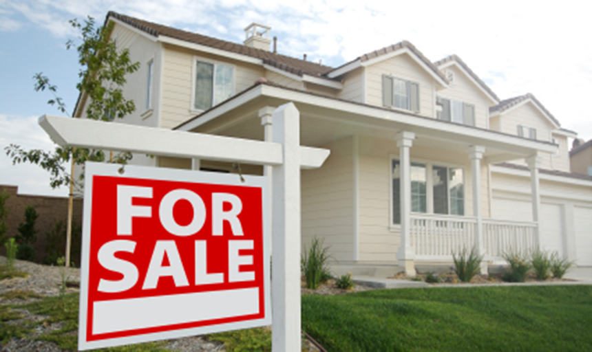 house with a "for sale" sign on the lawn