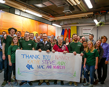outdoor adventure students holding up a banner that reads, "thank you nancy, kathy, steve, andy, mac and marcy!"