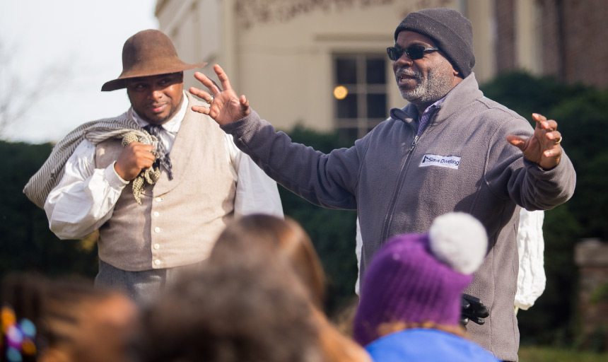 Two men telling stories to a crowd in front of Monterey House on Roanoke College campus