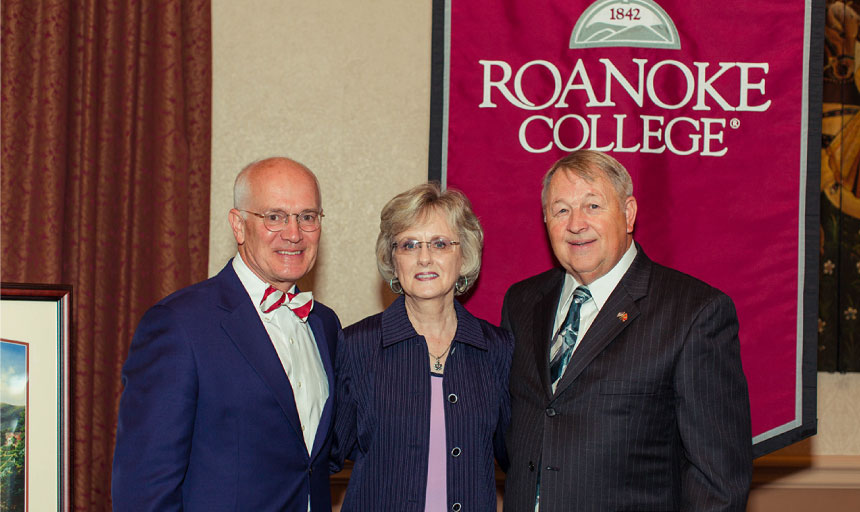 President Mike Maxey, Lois Ann Bryant, and James Bryant in front of Roanoke College banner.