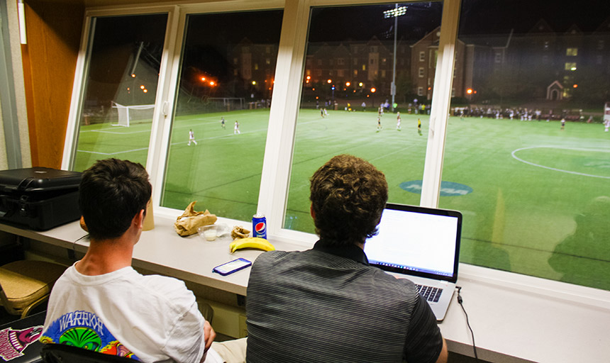 Crew members track a game from Kerr stadium's press book