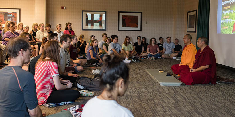 The Tibetan Monks leading students in a meditation session