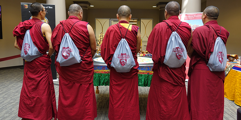 The Tibetan Monks wearing Roanoke College drawstring bags on their backs
