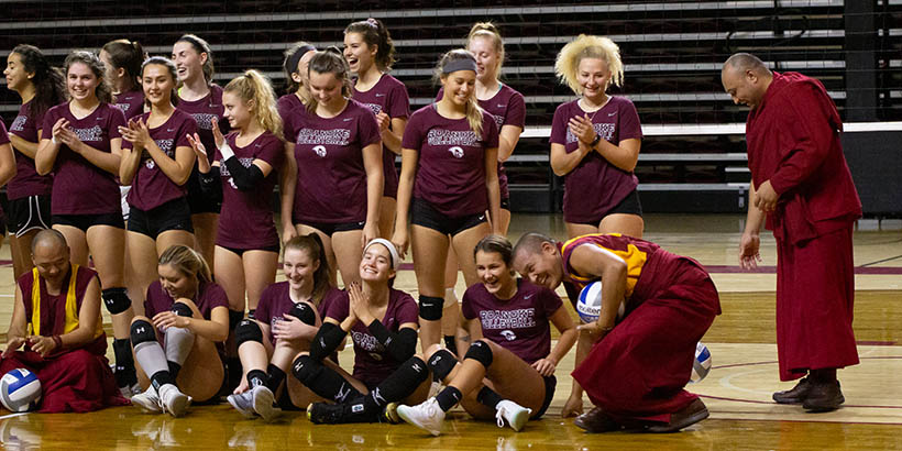 The Tibetan Monks laughing and posing for a photo with the volleyball team