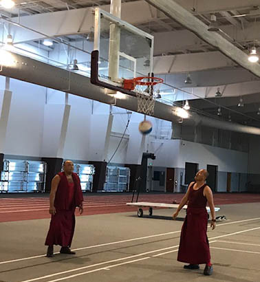 two of the tibetan monks playing basketball in the cregger center