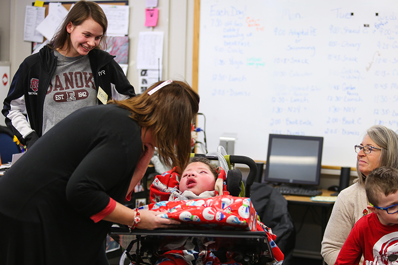 Student in wheelchair receiving toy.