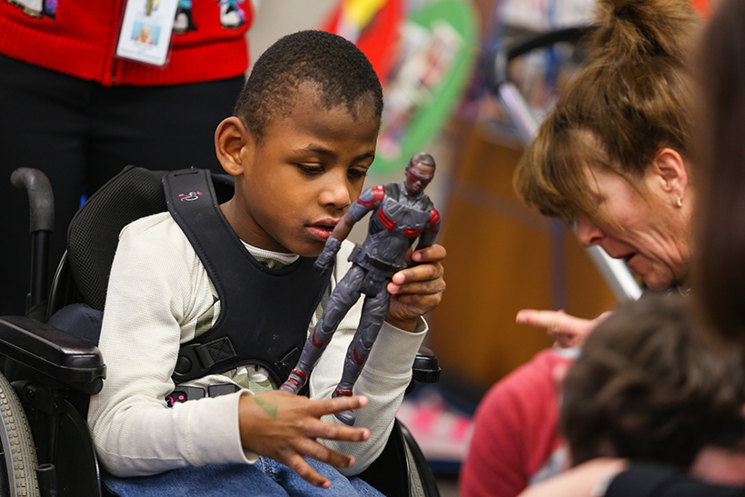 Child in wheelchair with action figure.