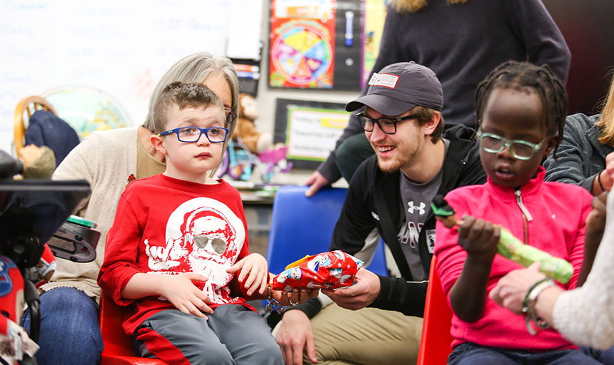 RC swim team student delivers toy to child.