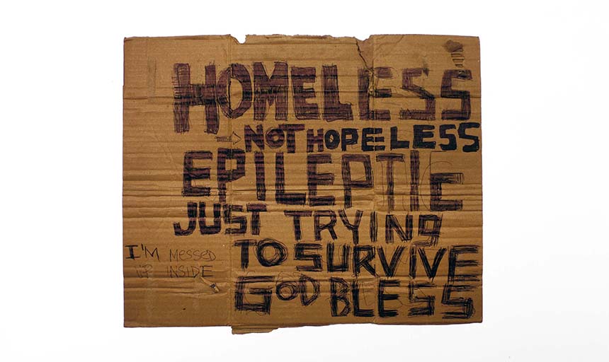 Cardboard, written in pen: "Homeless not hopeless. Epileptic just trying to survive God bless. I'm messed up inside."