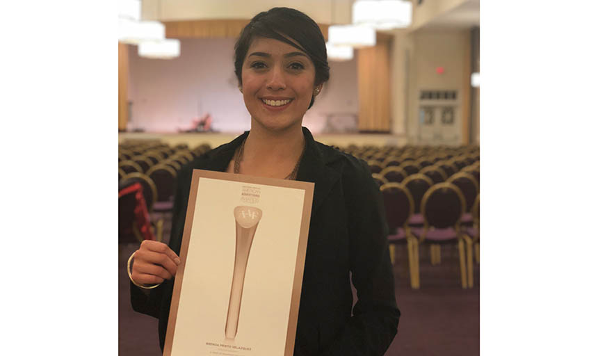 Brenda Prieto-Velazquez holding her ADDY award at the competition reception