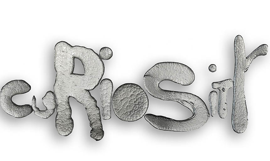 the word curiosity spelled out in poured and mirrored glass