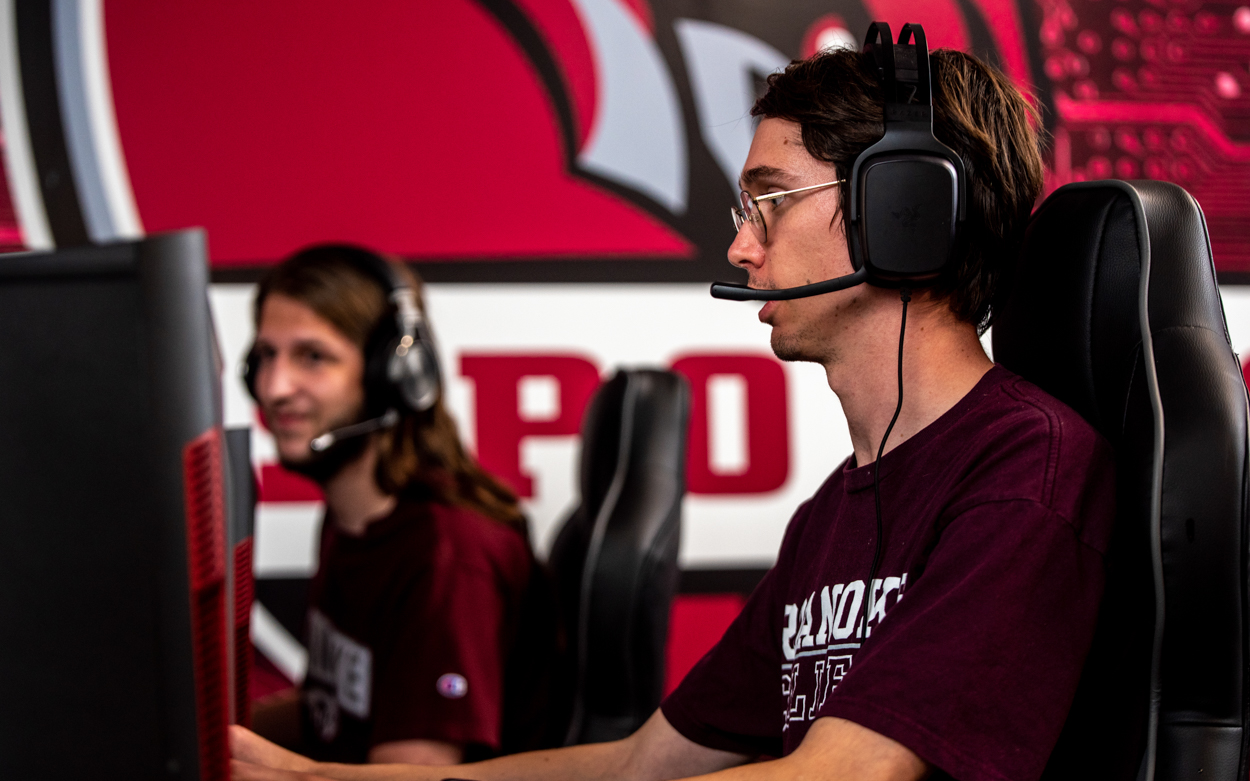 two students at computers with headsets