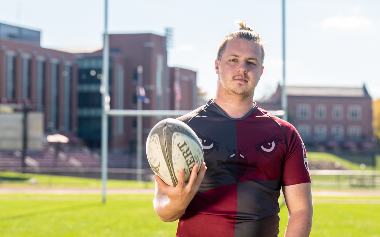 student holding rugby ball