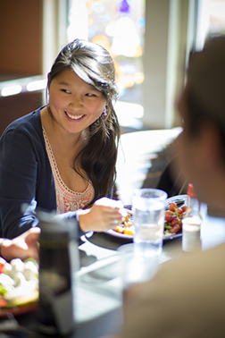 Student smiling and eating in The Commons