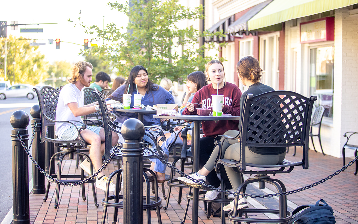 Students eat on the patio in front of Freshens