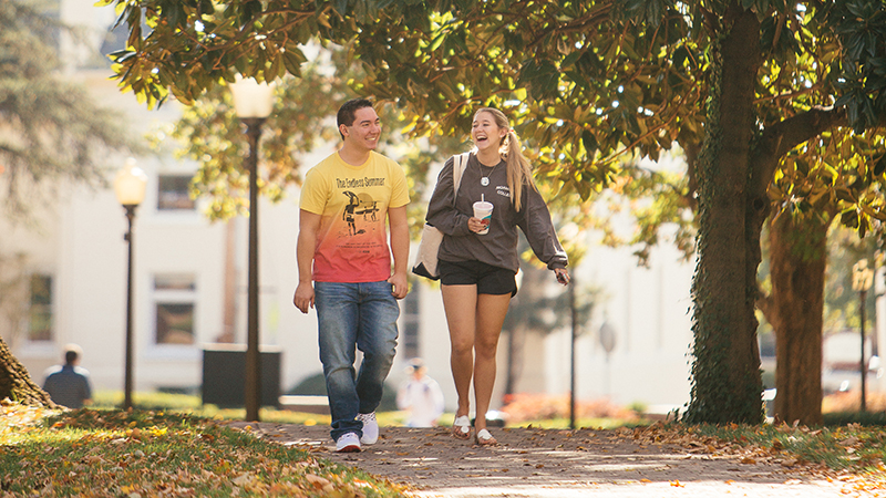 Two students walking across campus