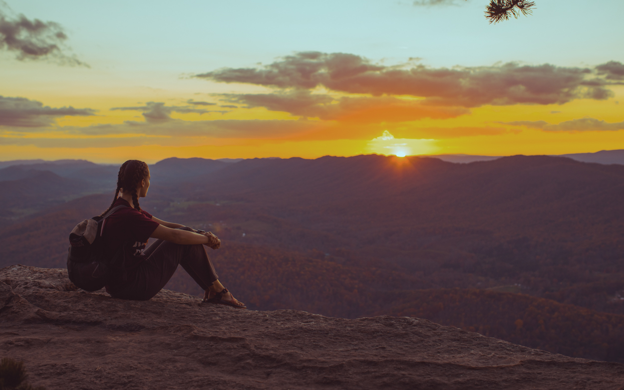 Student watching the sunset from Tinker Cliffs