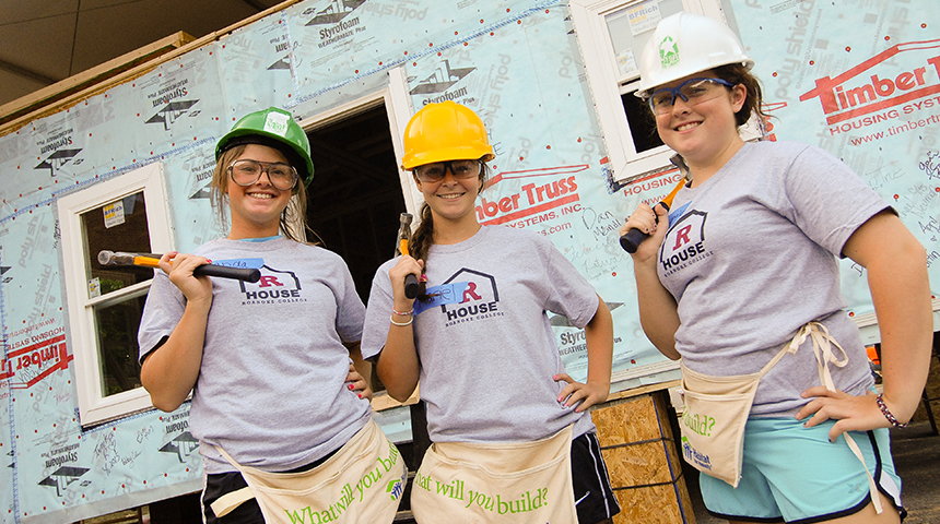 three students building a Habitat house